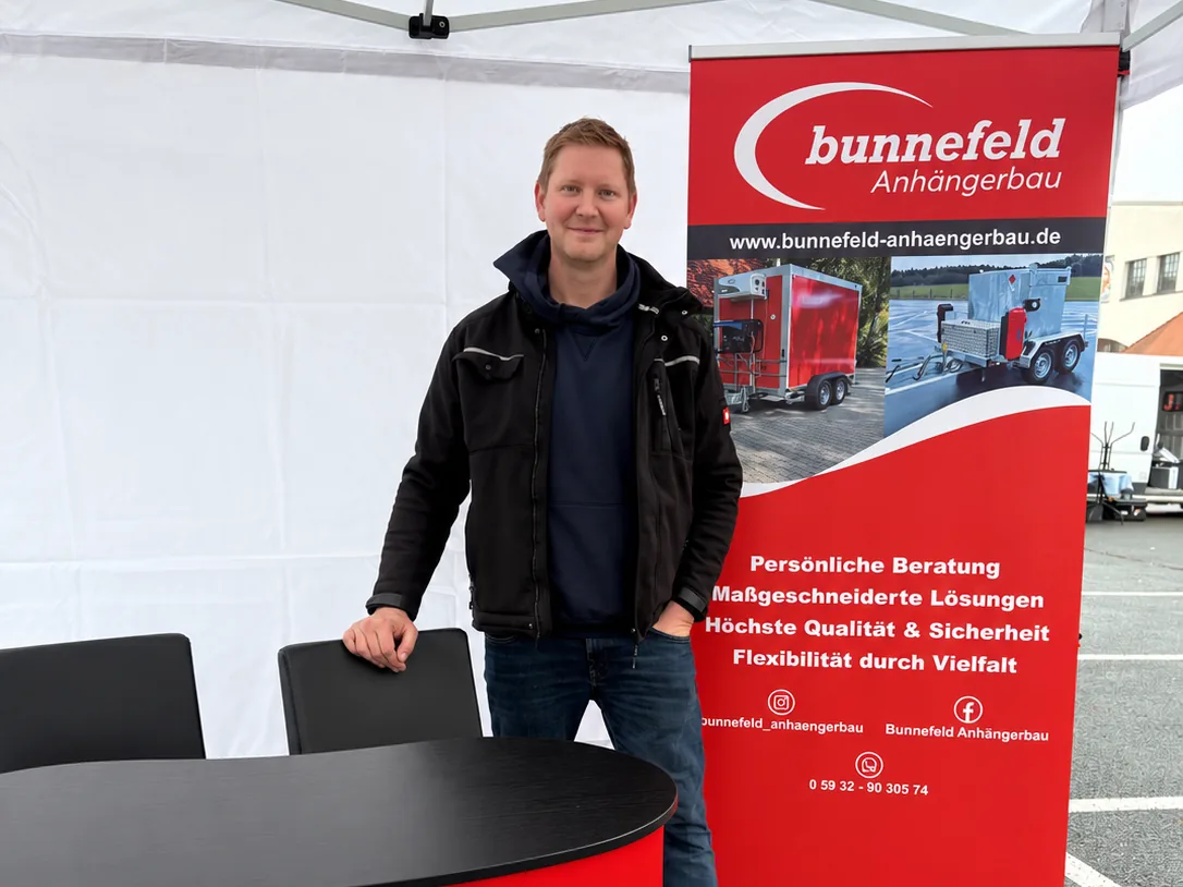 Ansprechpartner von bunnefeld Anhängerbau am Messestand mit Roll-up